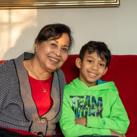 A mother and child smiling on a couch