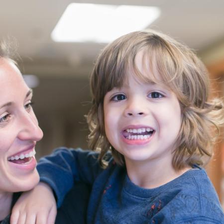 A child and adult smiling