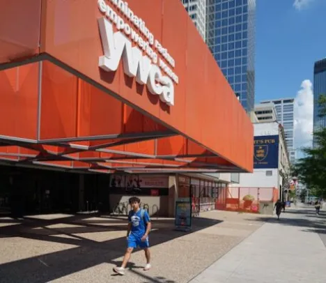 A person walking in front of the YWCA building