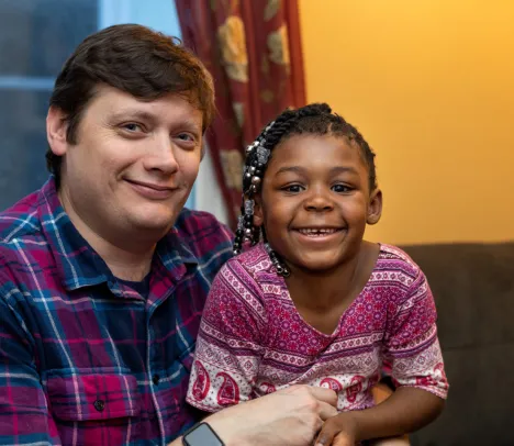 Halle smiling at the camera with an adult