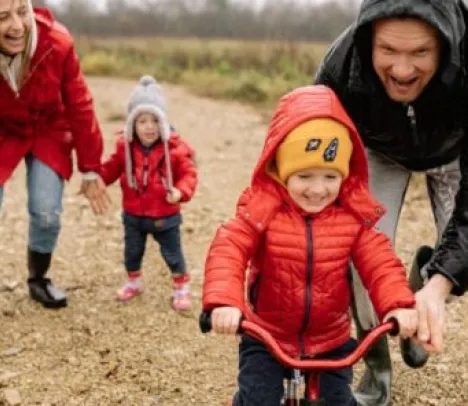 Parents with a smiling child riding a bike