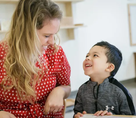 A woman and child smiling at each other