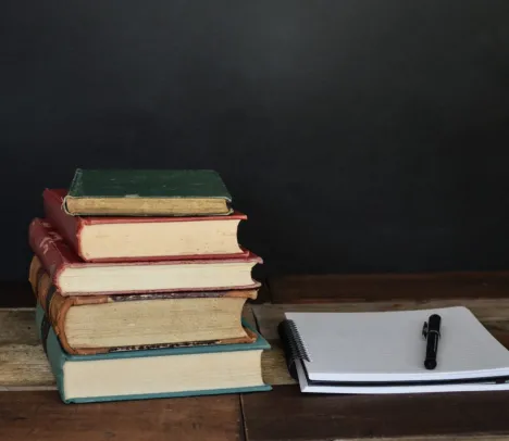 A stack of books and a note pad