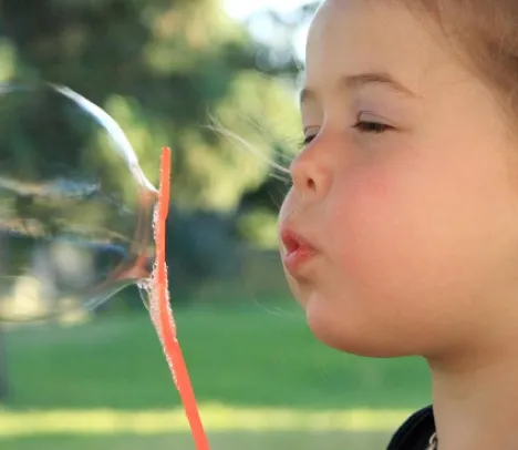 A child blowing a soap bubble