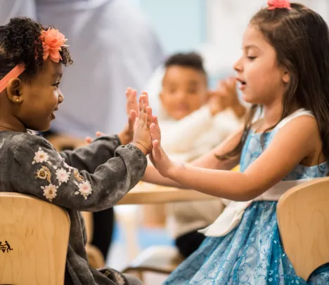 Two children playing and clapping hands