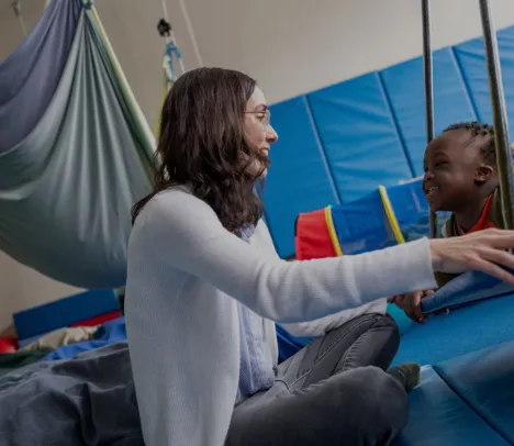 A child smiling and training in a gym