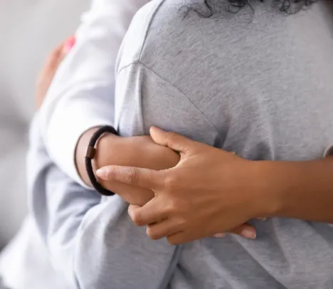 A close up of two people hugging