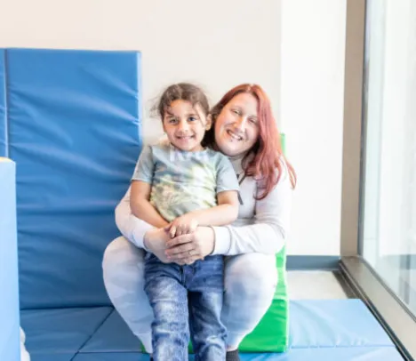 A woman hugging a smiling child