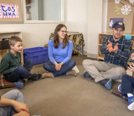 Kids and adults sitting in a semi circle