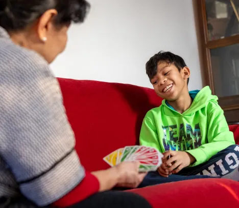 A child smiling and playing a card game