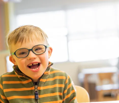 A child with glasses smiling