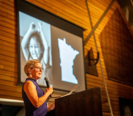A woman in front of a screen giving a presentation