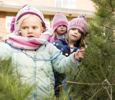 little girls on scavenger hunt in fir trees