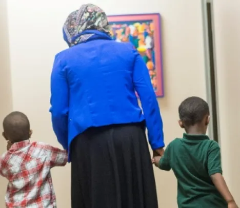 somali woman walking away from camera with two boys