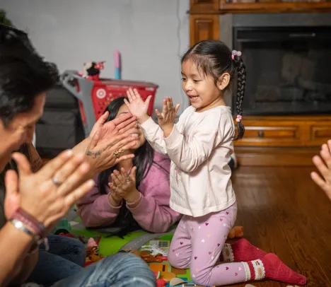 little girl plays and sings with her family 