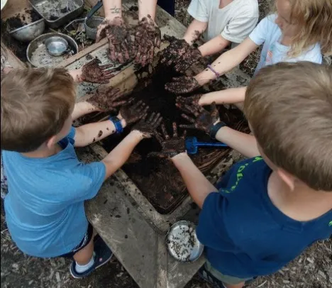 preschool kids getting mud all over their hands
