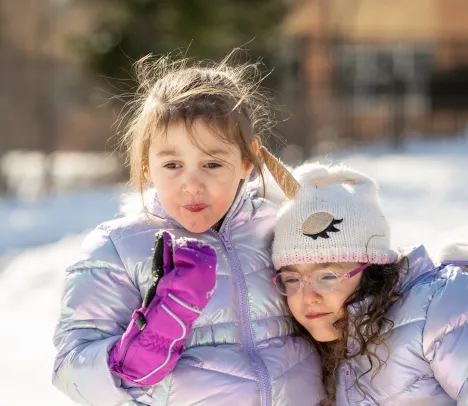 two sisters playing on the playground in the winter