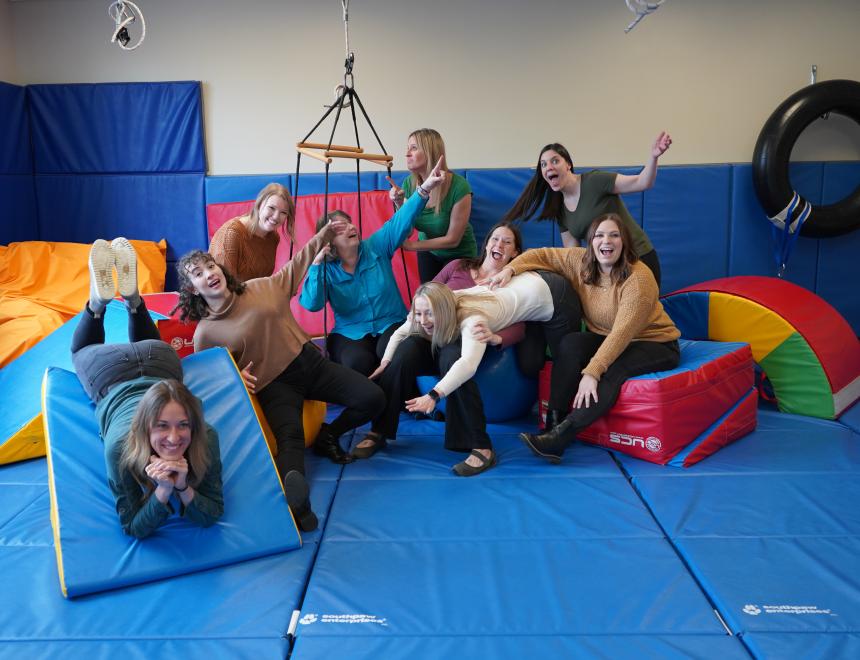 Group of Speech Therapy staff having fun in an OT gym.
