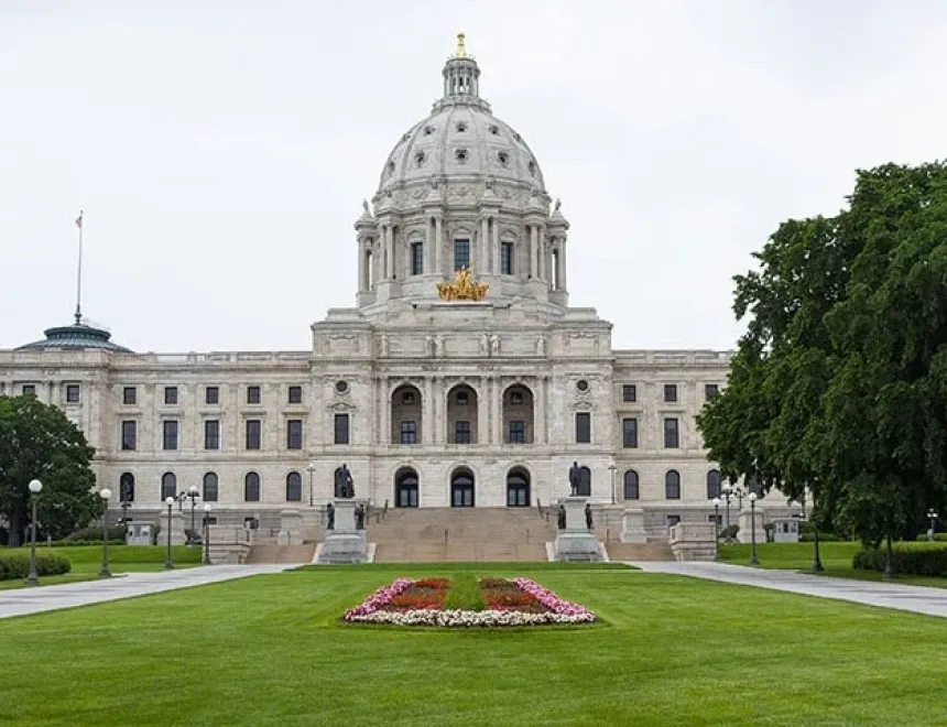 Photo of a brick building surrounded by trees on a sunny day.