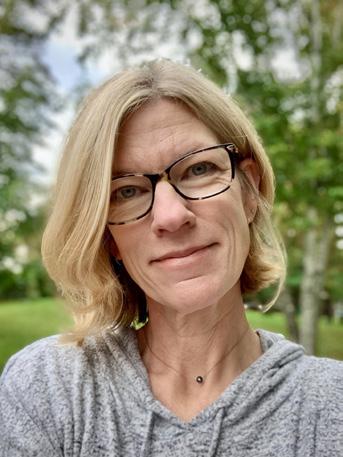 Portrait of blonde woman with glasses smiling. 