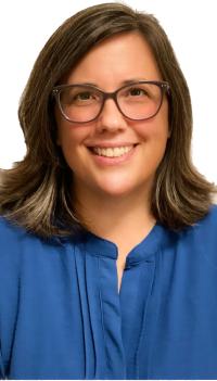 Brunette white woman with glasses wearing a royal blue top