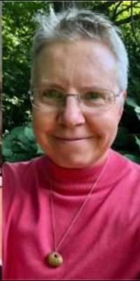 female teacher with white hair and pink shirt