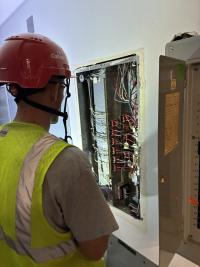 construction worker looks at electrical box