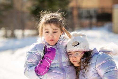 two sisters playing on the playground in the winter