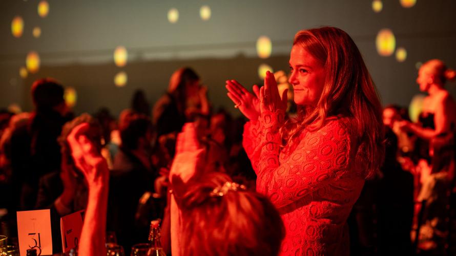 Co-chair receiving applause at gala. 