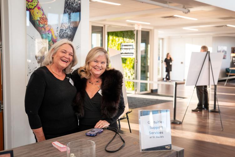 Two female volunteers at coat check station at gala.