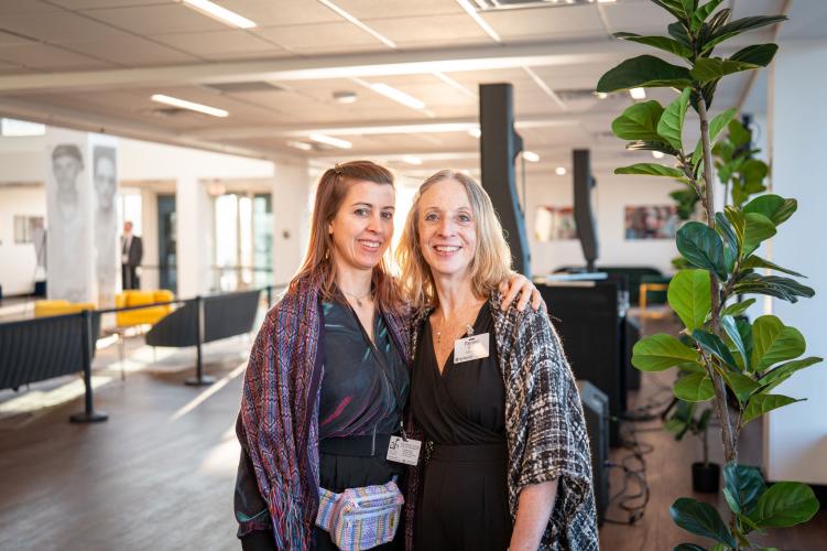 People standing in lobby of gala space, smiling. 