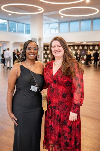 Two women in lobby of gala event, smiling at the camera.