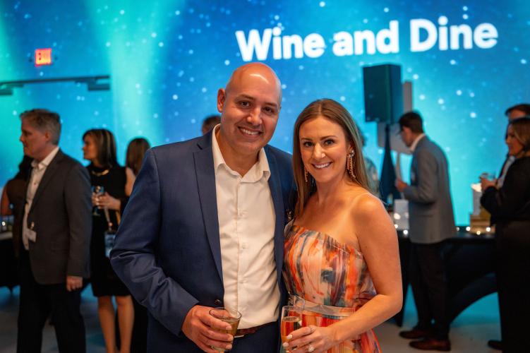 Man and woman in silent auction area of gala event. 
