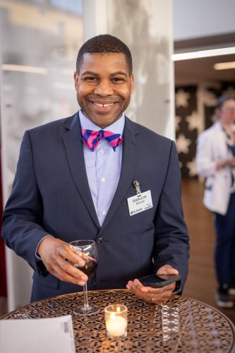 Man wearing a suite a bowtie standing in lobby of gala event.