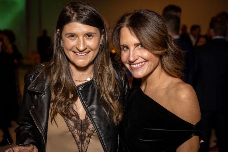 Two women smiling at the gala. 