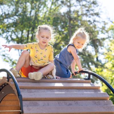 Two little girls playing on a bridge at St. David's Minnetonka playground.