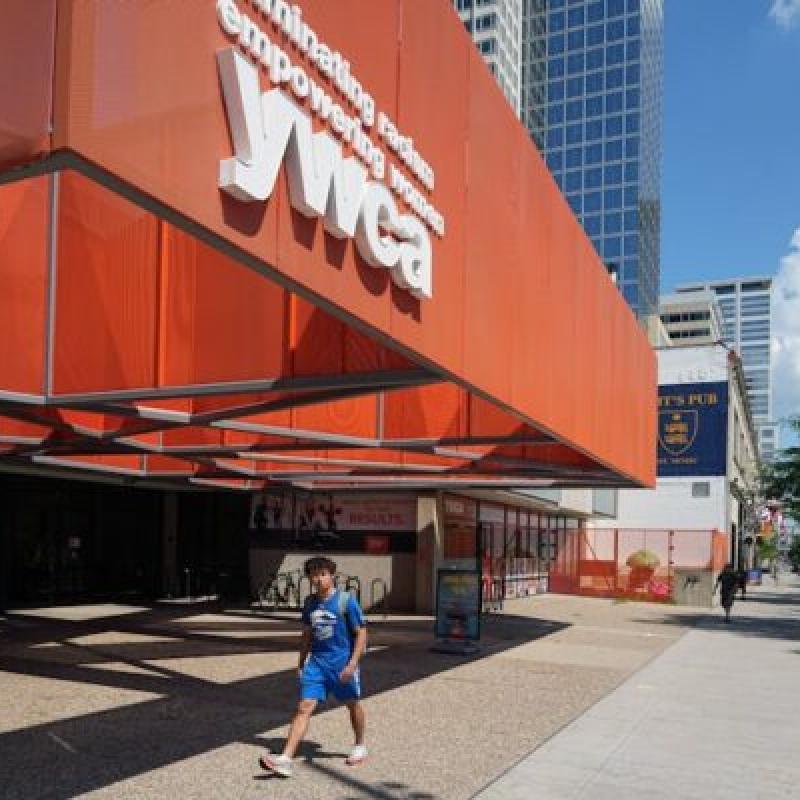 A person walking in front of the YWCA building