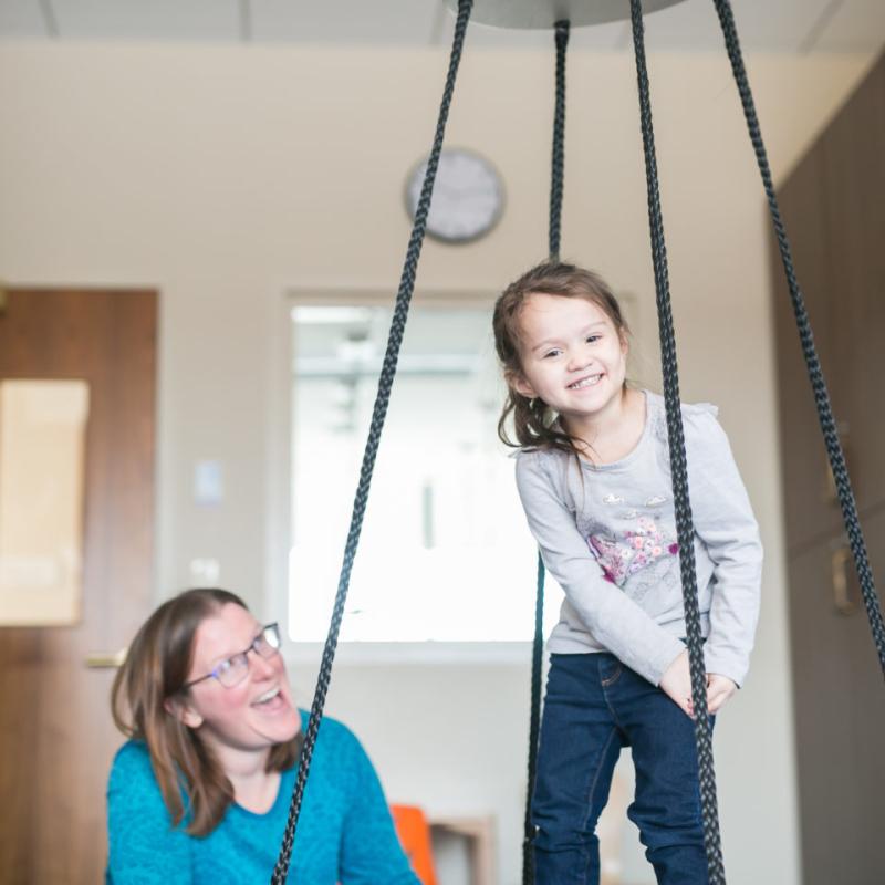 A child smiling and balancing with ropes