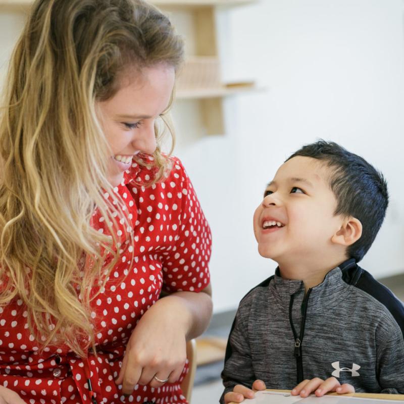 A woman and child smiling at each other