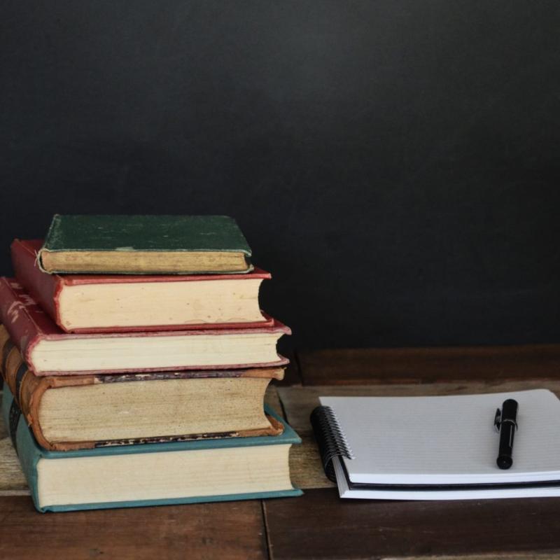 A stack of books and a note pad