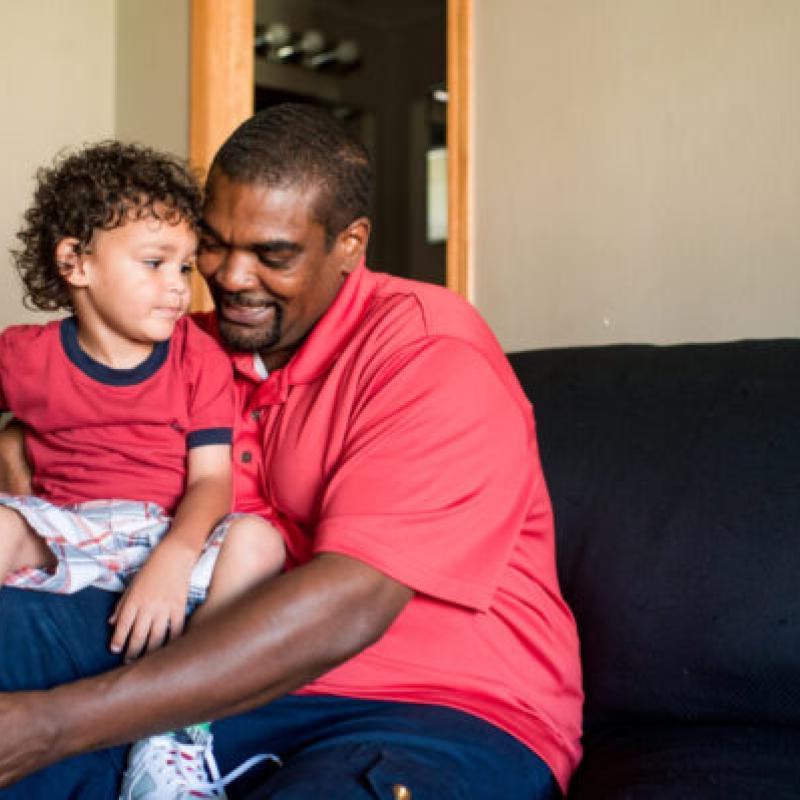 A father sitting with his son on his lap