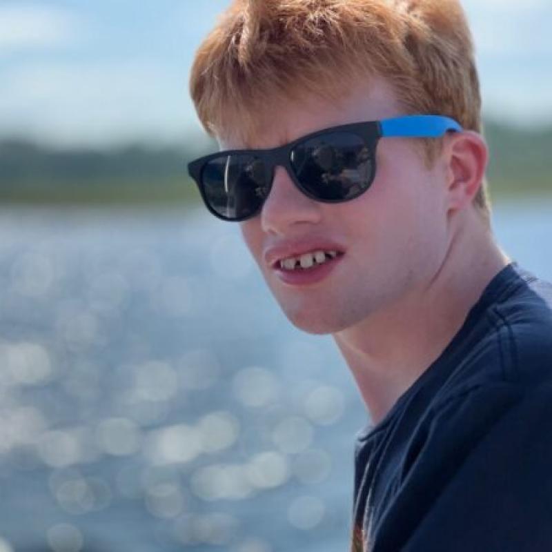 A teenager with sun glasses looking at the camera