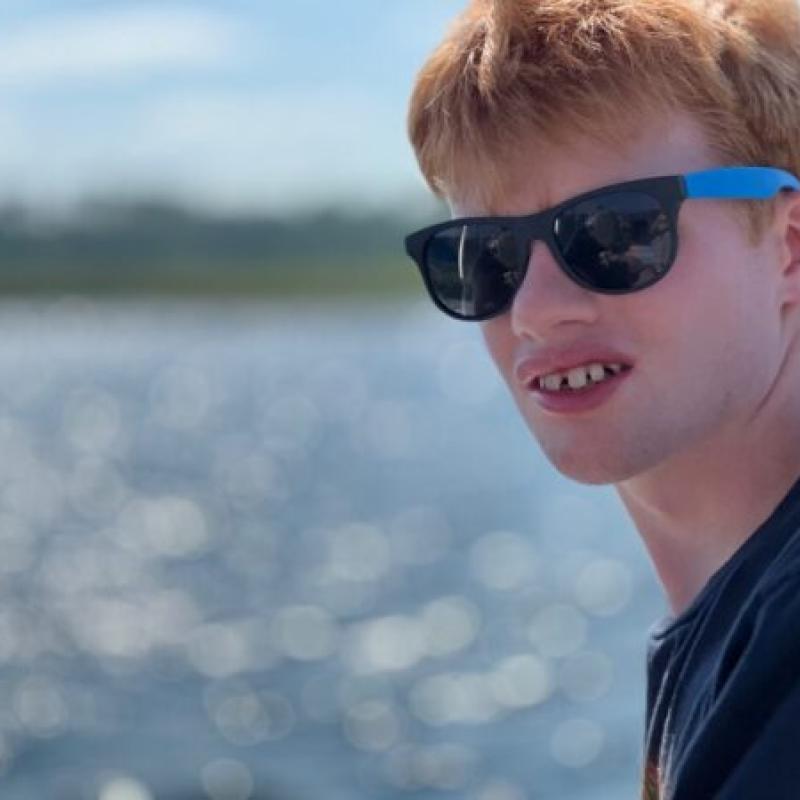 A teenager with sun glasses looking at the camera