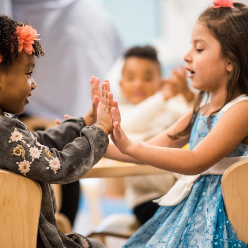 Two children playing and clapping hands
