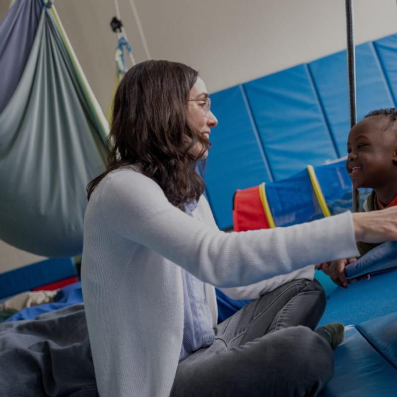 A child smiling and training in a gym