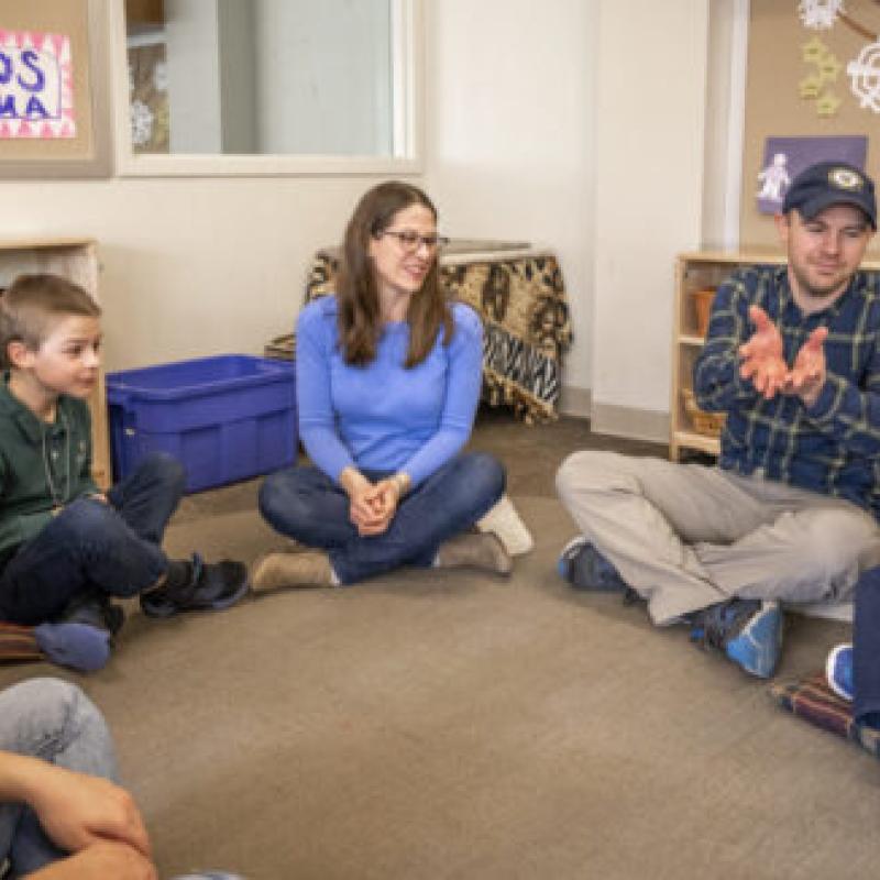 Kids and adults sitting in a semi circle