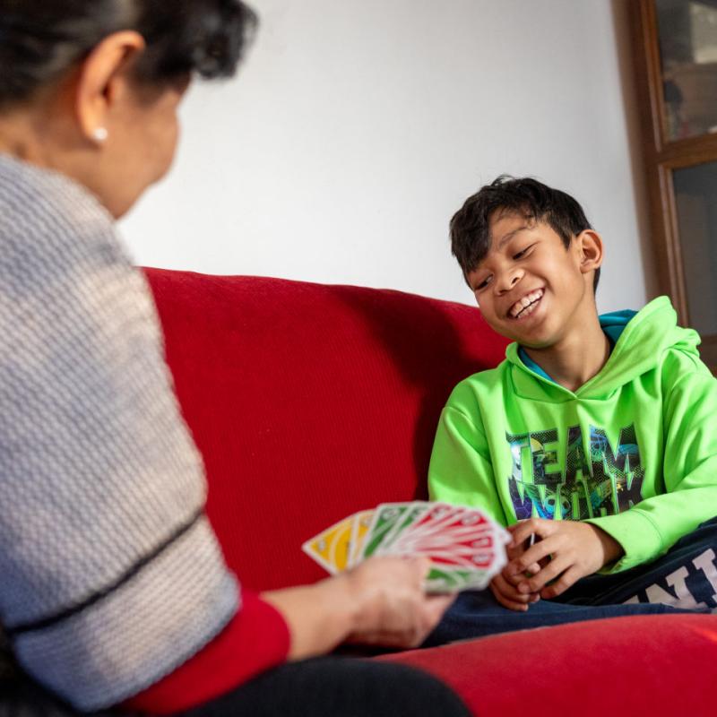 A child smiling and playing a card game