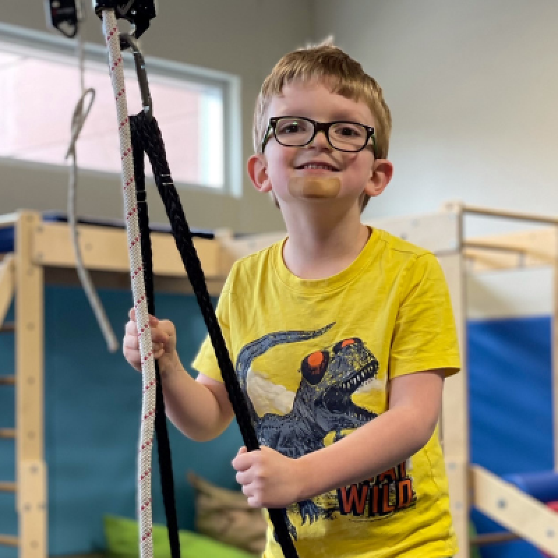 A smiling child holding a rope