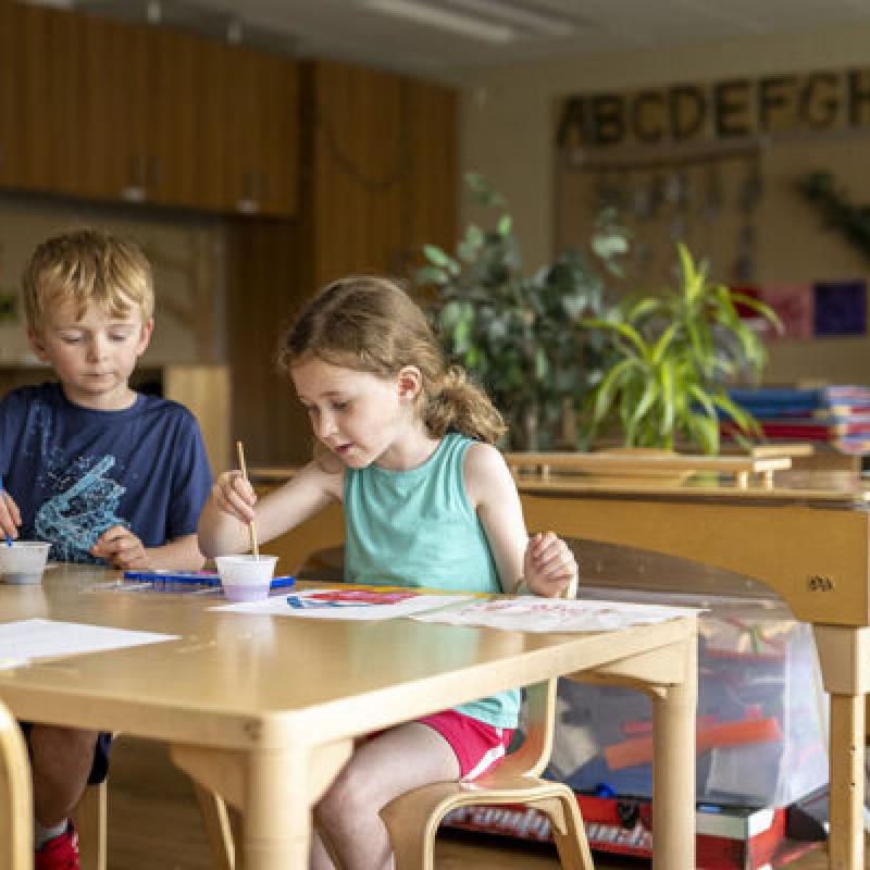 Two children doing art in a classroom
