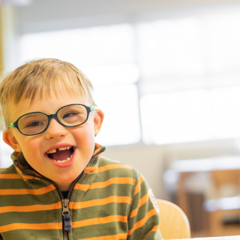 A child with glasses smiling